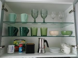 a cupboard filled with green glasses and plates at La Lunita in Valverde