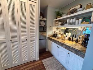a kitchen with white cabinets and a counter top at Honu Hideaway Studio at Royal Garden in Honolulu
