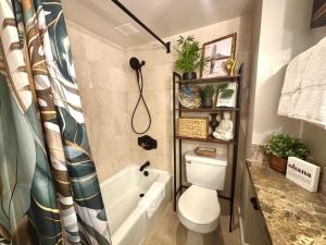 a bathroom with a toilet and a bath tub at Honu Hideaway Studio at Royal Garden in Honolulu