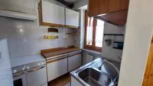 a kitchen with white cabinets and a sink and a window at LinHaus in Limone Piemonte