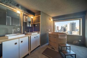 a bathroom with two sinks and a large window at Mi-Kan Design Hotel 藏前駅 in Tokyo