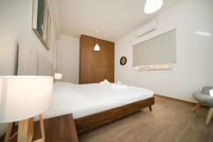 Near City center 1 bedroom flat في نيقوسيا: غرفة نوم بسرير ابيض وكرسي