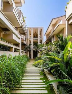 a walkway leading to a large apartment building at Da Alohas Hibiscus Oasis Pool Facing Candolim in Betim