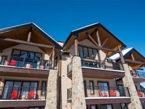 an apartment building with red chairs on balconies at Domaine Nymark in Saint-Sauveur-des-Monts