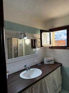 un baño con lavabo y espejo en Sardegna Porto San Paolo, en Porto San Paolo 24 fotos más