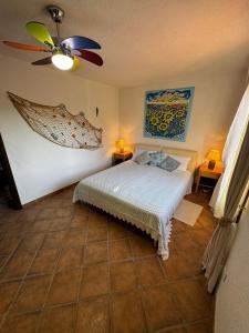 Un dormitorio con una cama y un ventilador de techo. en Sardegna Porto San Paolo, en Porto San Paolo