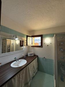 un baño con lavabo y espejo en Sardegna Porto San Paolo, en Porto San Paolo