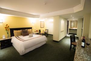 pokój hotelowy z dużym łóżkiem i jadalnią w obiekcie Hotel Ticuán w mieście Tijuana
