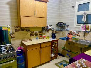 a kitchen with wooden cabinets and a sink at Room for rent - downtown in Cairo