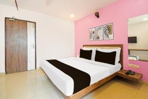 a bedroom with a large bed with a pink wall at Townhouse Mancheswar Bhubaneswar Formerly Kamla Inn in Bhubaneshwar +26 photos