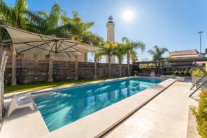 卡塔尼亚西亚拉比斯卡里住宿加早餐旅馆的带遮阳伞和灯塔的游泳池