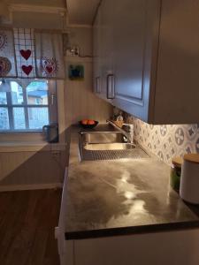 a kitchen with a sink and a counter top at Huset i Stamsund in Rishaugen