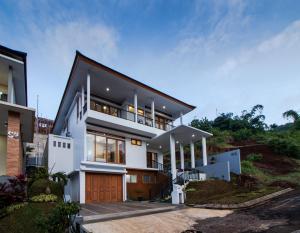 a white house with a black roof at Family Only Villa Private Pool with City View - De Reiz Ara Syariah 4BR in Ciburial