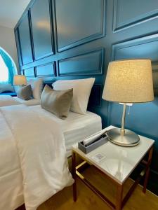 a bedroom with two beds and a table with a lamp at Regent Ramkhamhaeng 22 in Bangkok