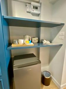 a small refrigerator in a kitchen with a blue shelf at Regent Ramkhamhaeng 22 in Bangkok +110 photos
