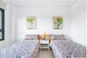 a room with two beds and a table with a lamp at Casa Del Alba Golf in Alicante +22 photos
