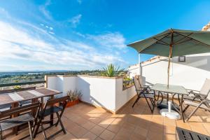 a patio with a table and chairs and an umbrella at Casa Del Alba Golf in Alicante