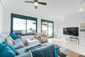 a living room with a blue couch and a tv at Casa Del Alba Golf in Alicante