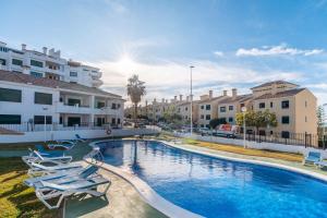 a swimming pool with lounge chairs and buildings at Casa Del Alba Golf in Alicante