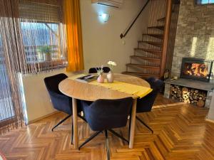 a dining room with a table and chairs and a fireplace at Holiday Home Bella Vita in Gornji Mihaljevec