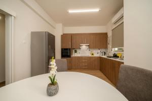 Near City center 1 bedroom flat في نيقوسيا: مطبخ مع طاولة بيضاء عليها مزهرية