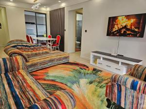 a living room with two couches and a flat screen tv at Ideal Homes in Nairobi +18 photos