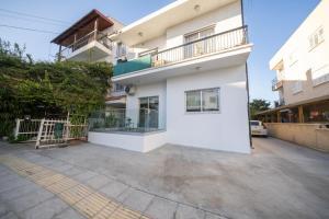 Near City center 1 bedroom flat في نيقوسيا: مبنى أبيض مع شرفة وموقف سيارات