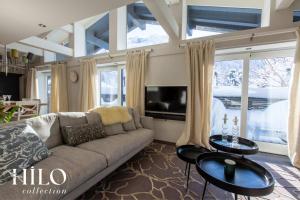 ein Wohnzimmer mit Sofa und Fernseher in der Unterkunft Chalet La Moraine Chamonix Mont Blanc by HILO Collection - 8 people - Jacuzzi and PS5 in Chamonix-Mont-Blanc