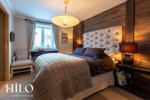 ein Schlafzimmer mit einem großen Bett mit großem Kopfteil in der Unterkunft Chalet La Moraine Chamonix Mont Blanc by HILO Collection - 8 people - Jacuzzi and PS5 in Chamonix-Mont-Blanc