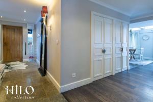 einen Flur mit weißen Türen und einem Esszimmer in der Unterkunft Chalet La Moraine Chamonix Mont Blanc by HILO Collection - 8 people - Jacuzzi and PS5 in Chamonix-Mont-Blanc + 22 Fotos