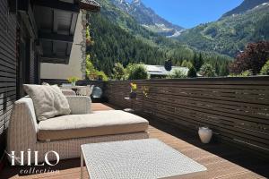 einen Balkon mit Stühlen, einem Tisch und Bergen in der Unterkunft Chalet La Moraine Chamonix Mont Blanc by HILO Collection - 8 people - Jacuzzi and PS5 in Chamonix-Mont-Blanc