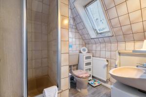 a bathroom with a toilet and a sink and a window at Erholung Pur in Hennstedt +19 photos