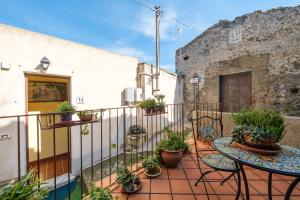 a balcony with a table and some potted plants at Holiday Home Tommaso e Martina in Savoca 