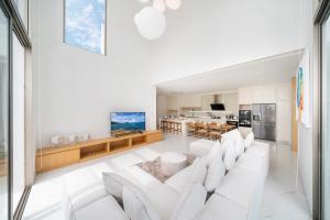 Ban Pak LakにあるBrand New & Modern Luxury 4BR Pool Villa in Residence Lux Pride 2 V12の白いソファとキッチンのあるリビングルーム