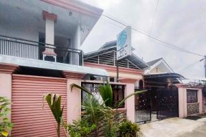 a pink house with a sign in front of it at RedDoorz at Amanah Syariah Residence Tanjung Karang Lampung in Tanjungkarang