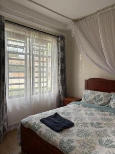 MuhoroniKameso Farm guest house的一间卧室，里面有一张床和一扇窗户。