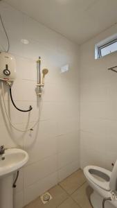 a shower in a bathroom with a toilet and a sink at Natol Homestay - LA Tabuan Jaya in Kuching