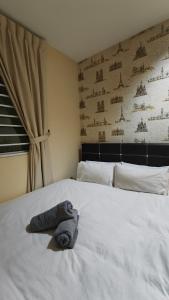 a towel laying on a bed in a bedroom at Natol Homestay - LA Tabuan Jaya in Kuching