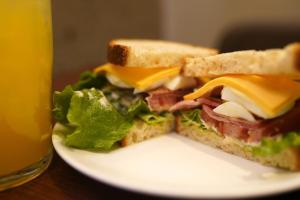 ein Sandwich auf einem Teller neben einem Glas Bier in der Unterkunft Takuto Hotel Osaka Shinsaibashi in Osaka