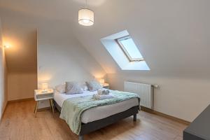 a bedroom with a bed and a skylight at Domaine de Larmor - Maison proche plages in Damgan