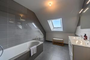 a bathroom with a tub and a sink and a window at Domaine de Larmor - Maison proche plages in Damgan