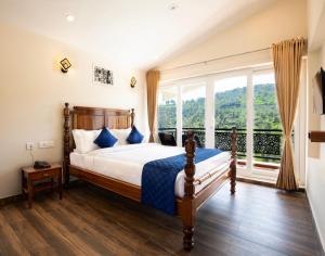 科塔吉里COASTAL GRAND RESORT - KOTAGIRI的一间带床和大窗户的卧室