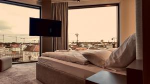a bed in a room with a large window at Bellman Hotel in Berlin