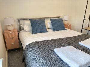 una camera da letto con un letto grande con cuscini blu di Forest House by STAE-Homes a Port Talbot