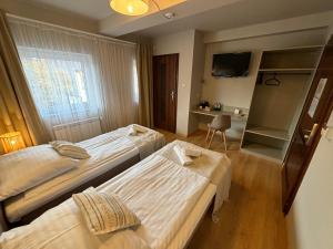 une chambre d'hôtel avec deux lits et une télévision dans l'établissement Bankietowa Hotel & Restauracja, à Ostrów Wielkopolski