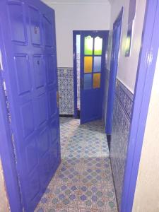 ein Flur mit zwei blauen Türen und einem Fliesenboden in der Unterkunft Khay in Safi
