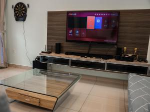 un salon avec une télévision et une table en verre dans l'établissement Seri Austin Landed GameHaus 16pax BBQ Mahjong by Our Stay, à Johor Bahru