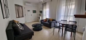 salon z kanapą i stołem w obiekcie apartamento céntrico jerez calle tucan n17 w mieście Jerez de la Frontera