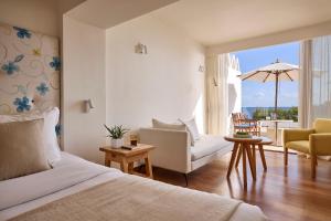 a bedroom with a bed and a living room at St. Nicolas Bay Resort Hotel & Villas in Agios Nikolaos +148 photos
