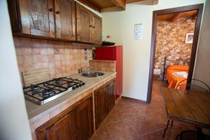 een keuken met een spoelbak en een fornuis bovenste oven bij Le Villette Luisa in Lampedusa +27 foto's